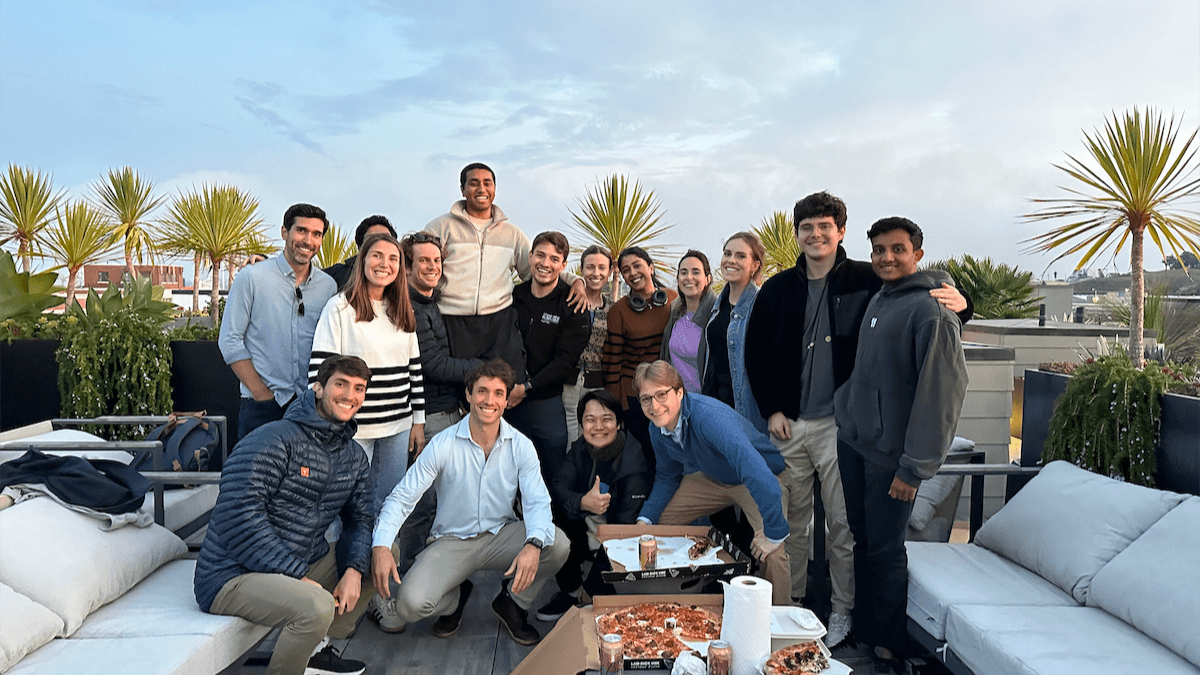The HappyRobot team together on a rooftop with pizza