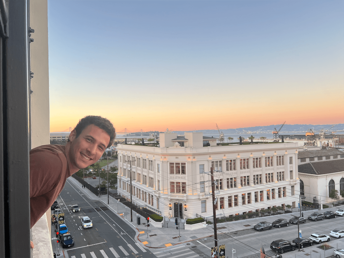 A teammate at the window overlooking San Francisco at sunset